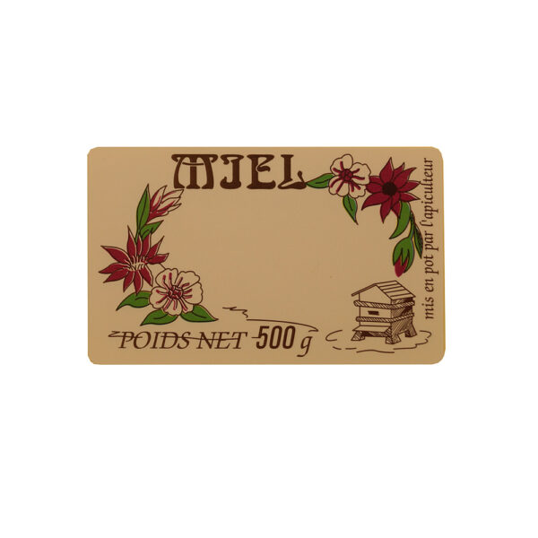 Étiquette beige décorée de fleurs rouges et blanches autour, texte MIEL et POIDS NET 500 g, bûcheron dessiné à droite.