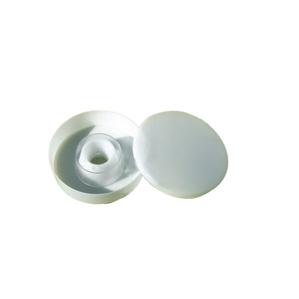 Bouton-pression en plastique blanc avec bouchon, posé sur disque plat.
