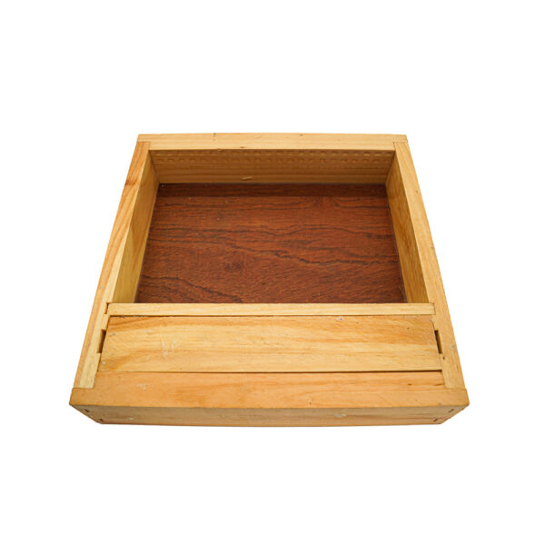 Coffre en bois rectangulaire avec plateau coulissant, posé sur une surface blanche.