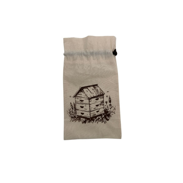 Sac en tissu beige avec pictogramme d’une ruche et herbes autour.